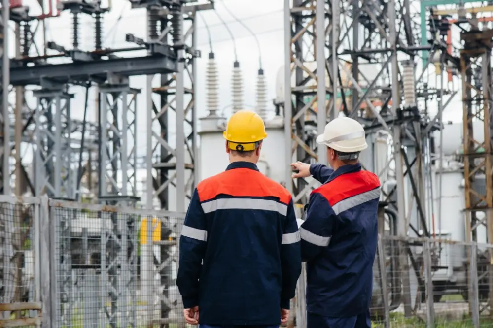 Pracownicy w odzieży ochronnej i kaskach przy infrastrukturze elektroenergetycznej – szkolenia na uprawnienia G1, G2, G3